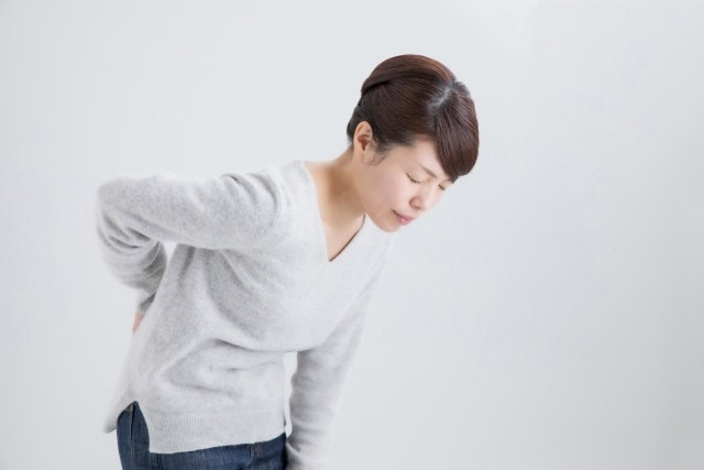 腰を押さえる女性